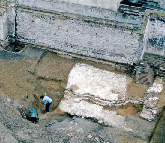 The Roman wall and bastion during the excavation. Ian Blair and Geoff Egan (at bottom left) are excavating a section through the V-cut defensive ditch contemporary with the wall. The foundation of the later Roman bastion was stepped and purposely deepened where it overlay the earlier ditch