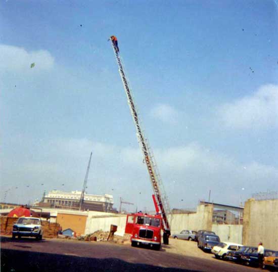 Rising to even greater heights No.2: Mark Harrison at the top of Fire engine ladder (looking west)