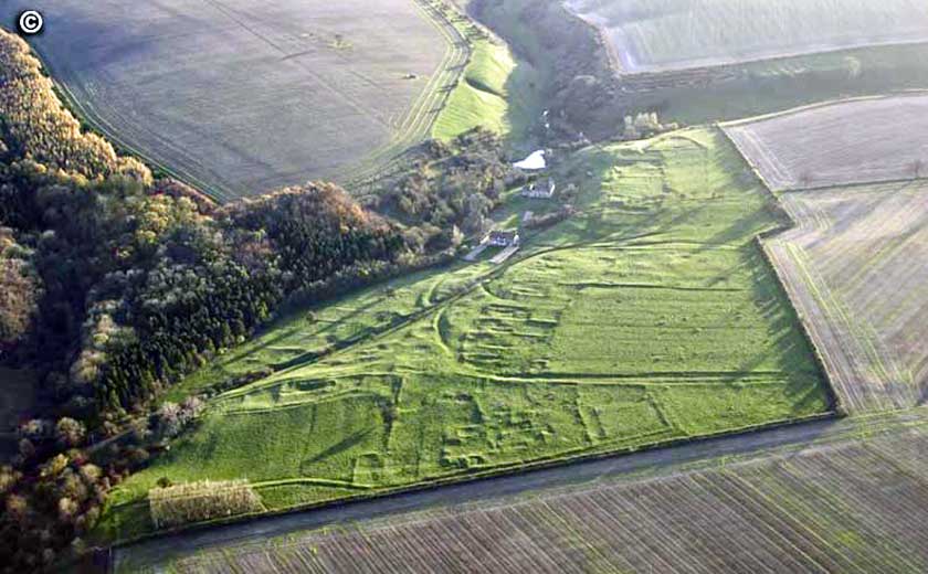  Aerial view of WP looking S,  with the earthworks of the C13th northern Manor in the foreground. The holloway and the medieval villagers house sites can be seen on the higher ground,  whilst the remains of the church and the modern cottages are in the valley below